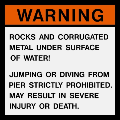 This is a warning sign located at the beach explaining hazards, and warning swimmers not to jump or dive from the pier into Lake Michigan.